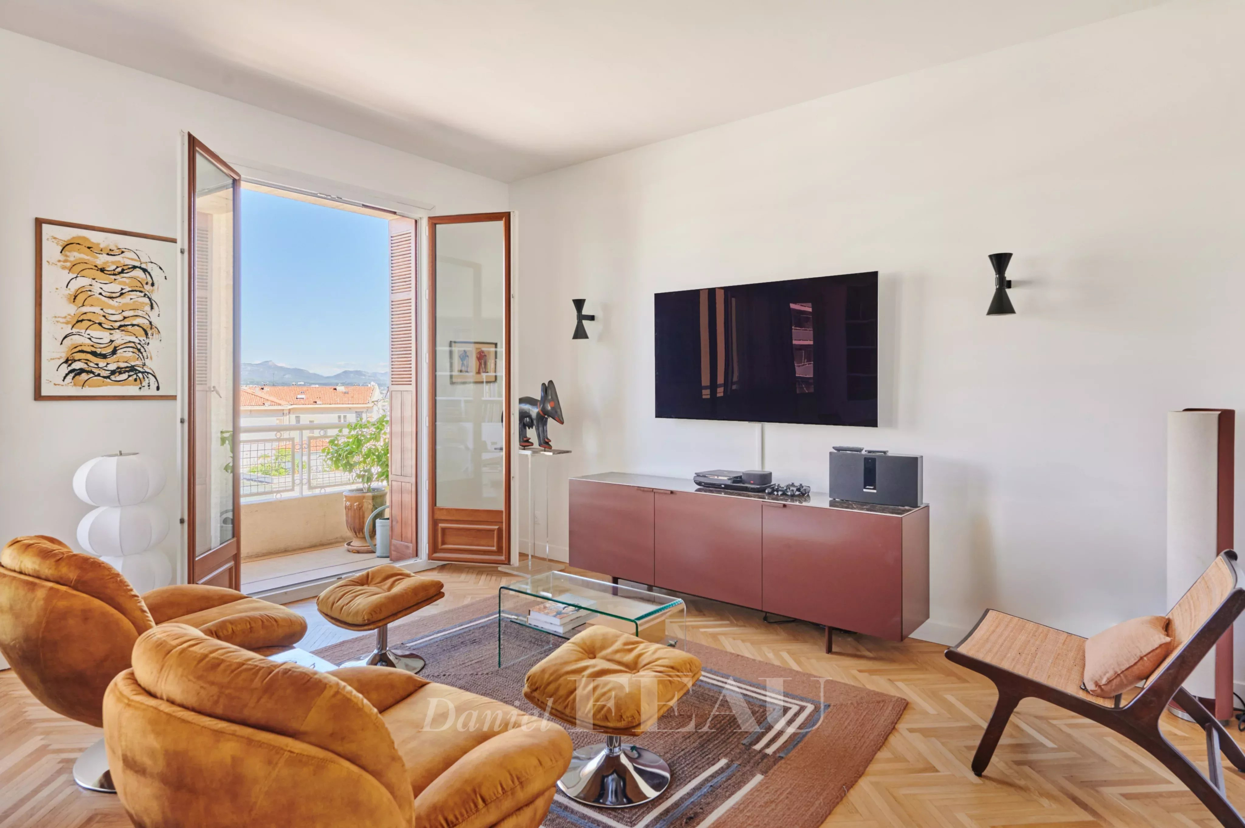 Salon d’appartement rénové à Marseille 8ème Salon lumineux d'un appartement rénové avec vue sur l'extérieur, mobilier moderne et télévision.