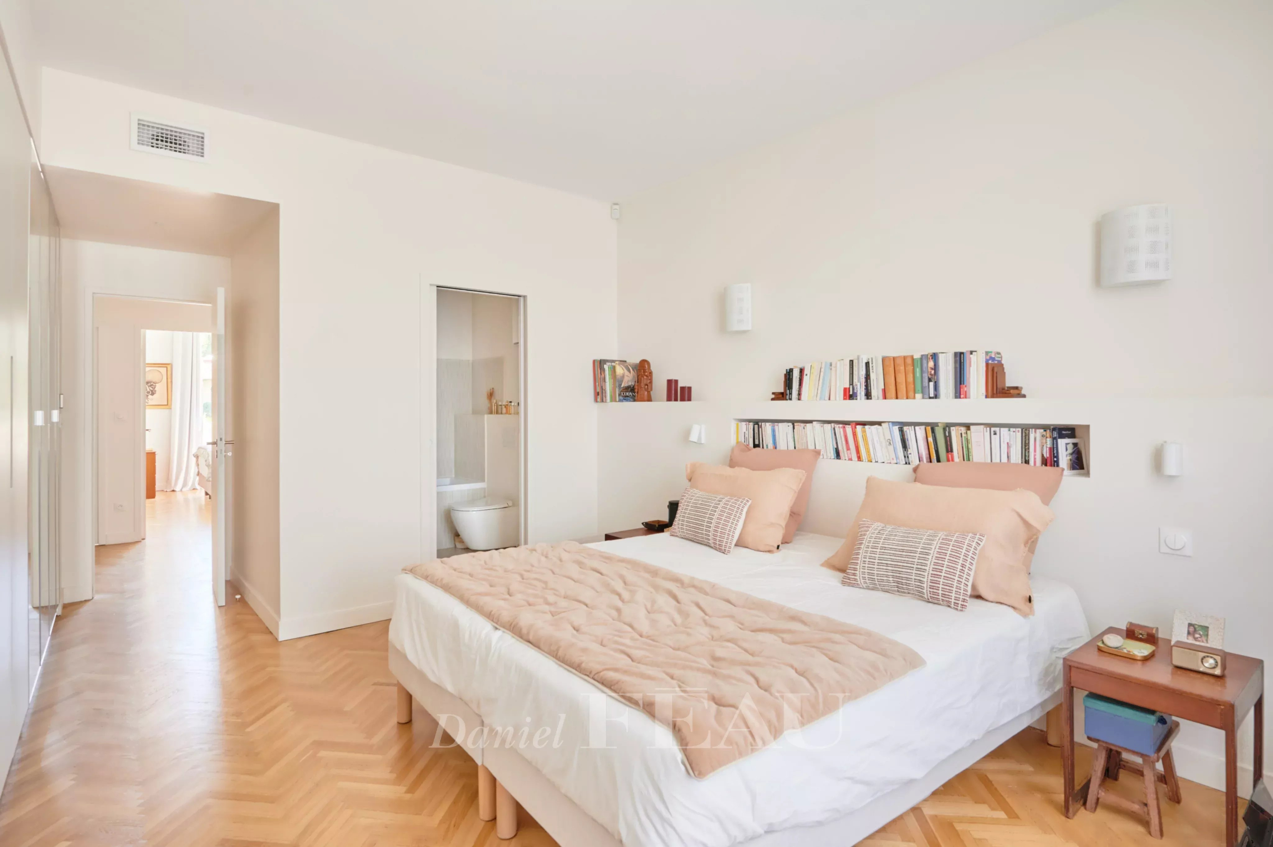 Chambre d’appartement rénové à Marseille Chambre d'un appartement rénové avec un lit double et des étagères, éclairée par la lumière naturelle.
