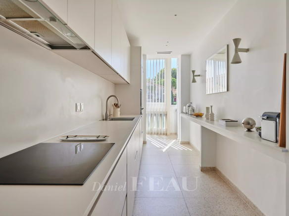 Cuisine moderne et lumineuse d'un appartement rénové à Marseille 8ème, avec plans de travail clairs et fenêtres.