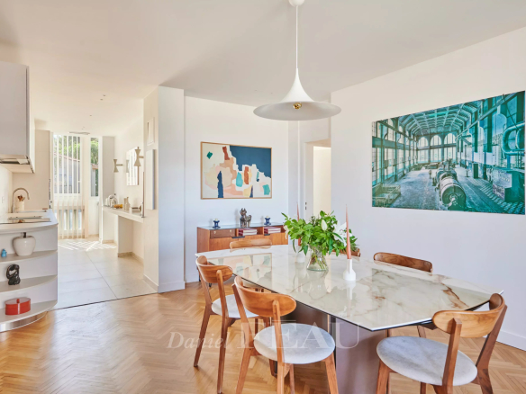 Salle à manger d'un appartement rénové avec une table en marbre et des chaises en bois, décor moderne.
