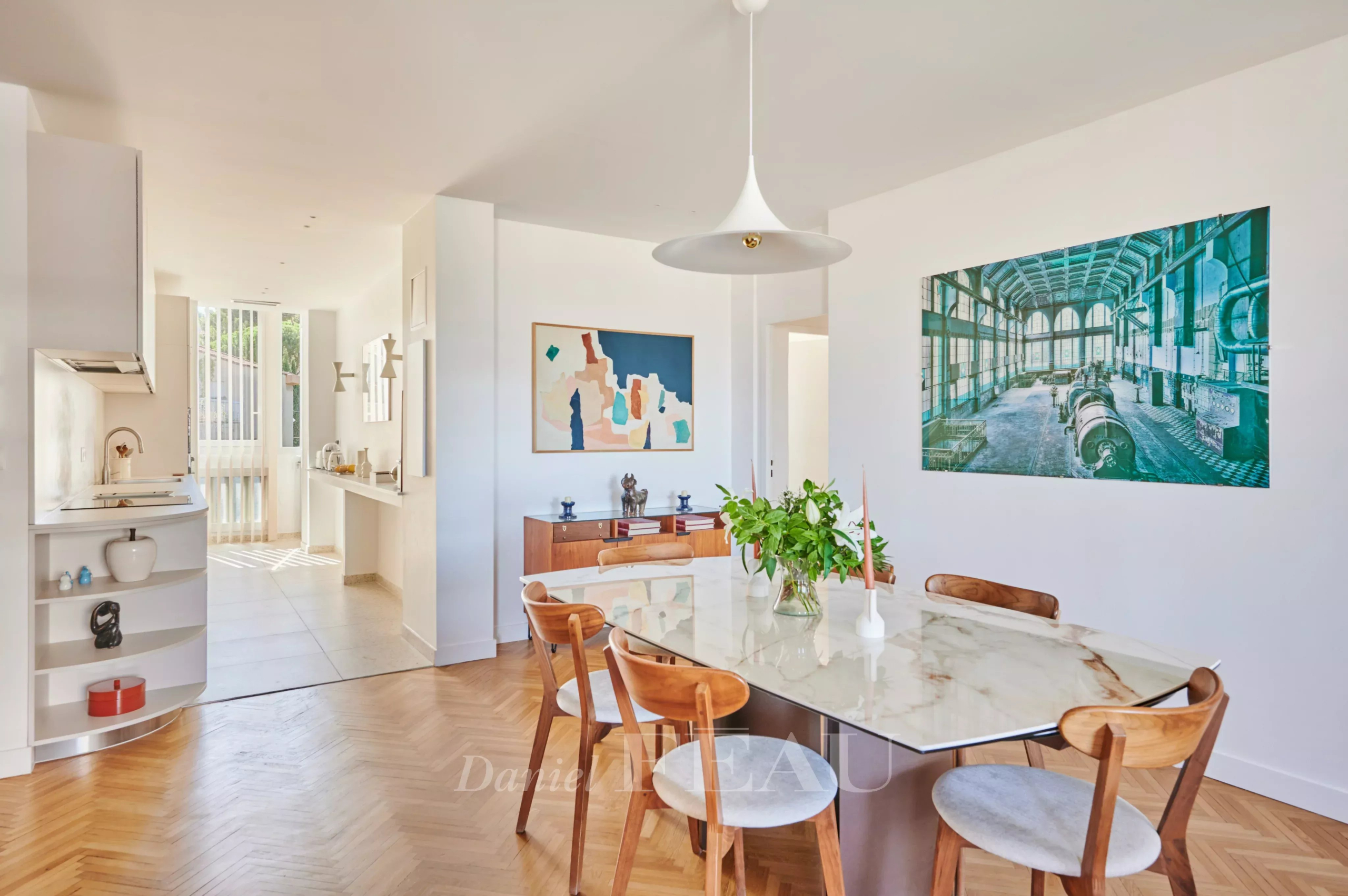 Appartement familial rénové à Marseille 8ème Salle à manger d'un appartement rénové avec une table en marbre et des chaises en bois, décor moderne.