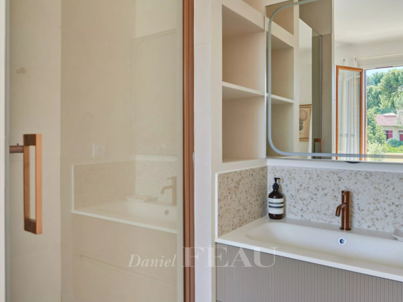 Salle de bain moderne avec douche et lavabo dans un appartement rénové à Marseille.