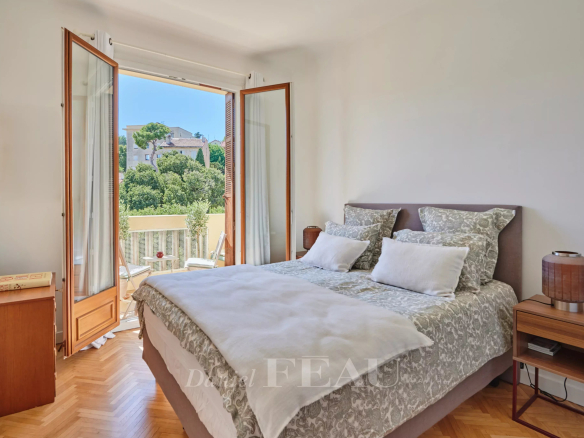 Chambre d'appartement rénové à Marseille avec balcon et vue sur jardin.