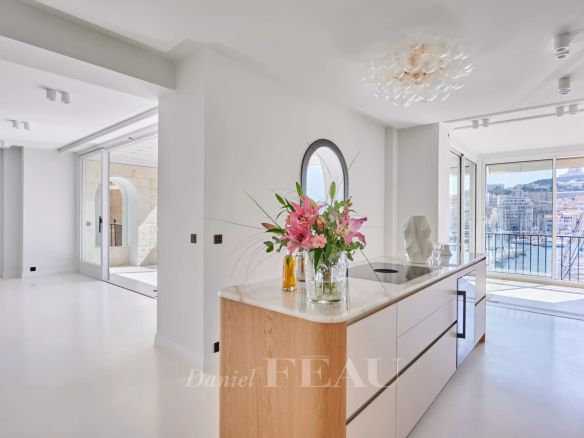 Intérieur d'un appartement rénové à Marseille avec vue sur le Vieux-Port, décoré avec des matériaux naturels.