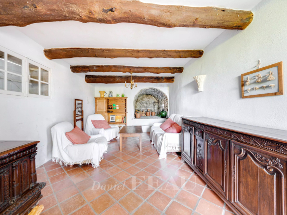 Intérieur d'une bastide en pierres avec poutres apparentes et mobilier en bois, Le Beausset.