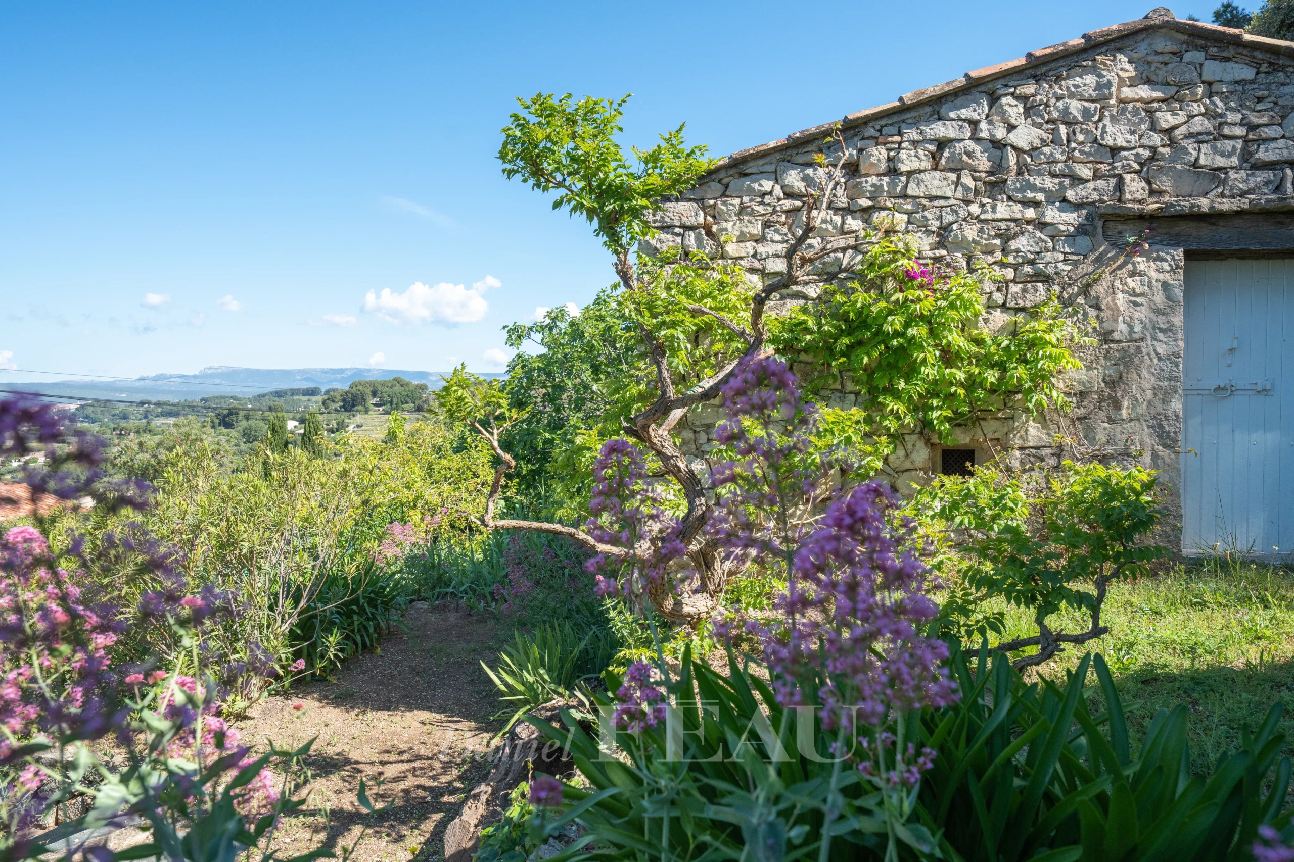 Bastide en pierres au Beausset Bastide en pierres avec jardin fleuri au Beausset, vue dégagée sur la campagne.