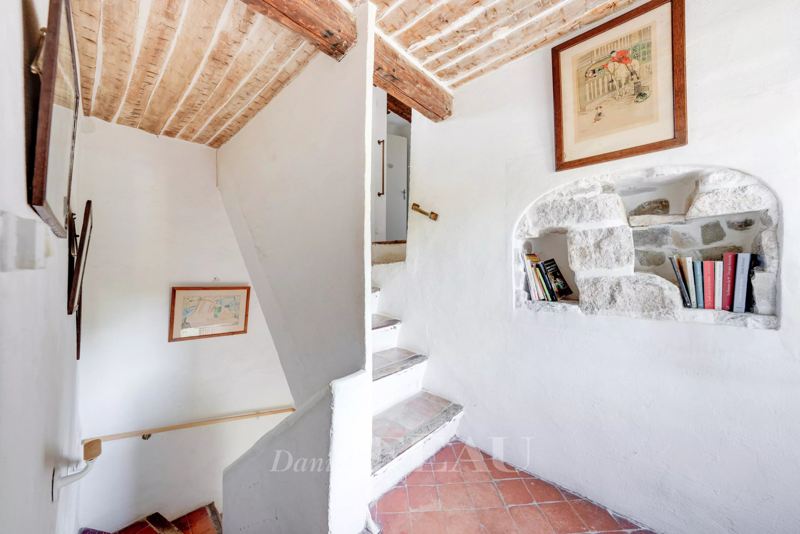 Escalier d’une bastide au Beausset Escalier intérieur d'une bastide en pierres avec murs blancs et éléments décoratifs.