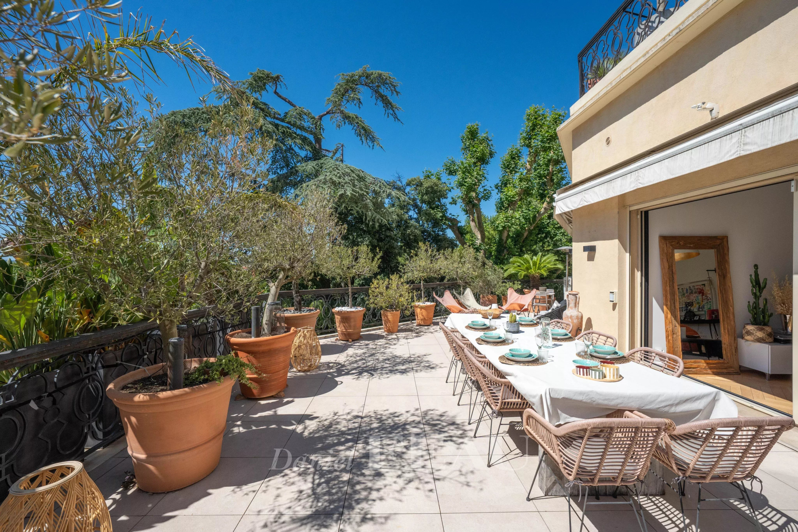 Terrasse d'un appartement avec tables dressées et plantes, Marseille 9ème.