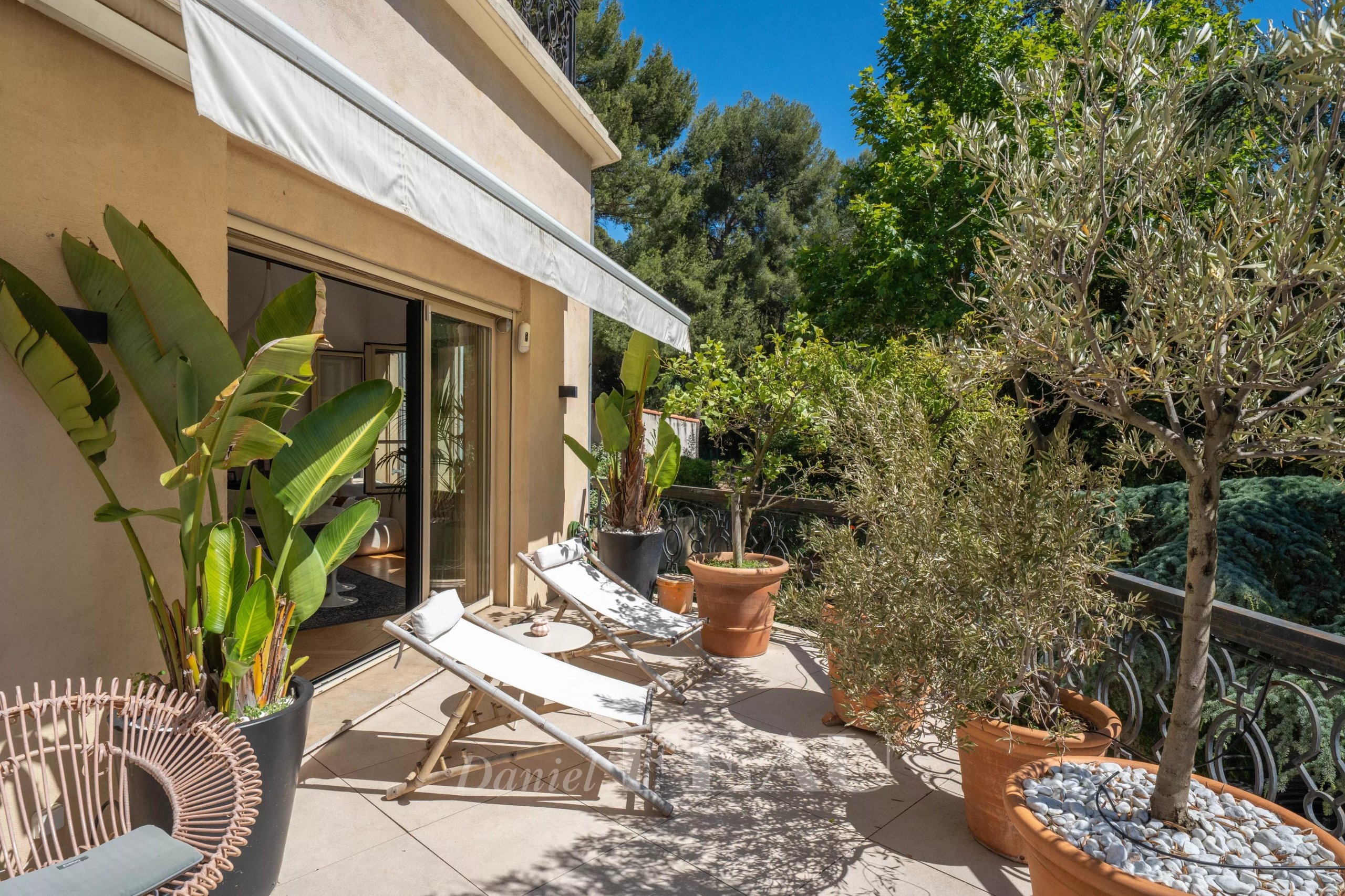 Terrasse d'un appartement avec chaises longues et plantes, Marseille 9ème.