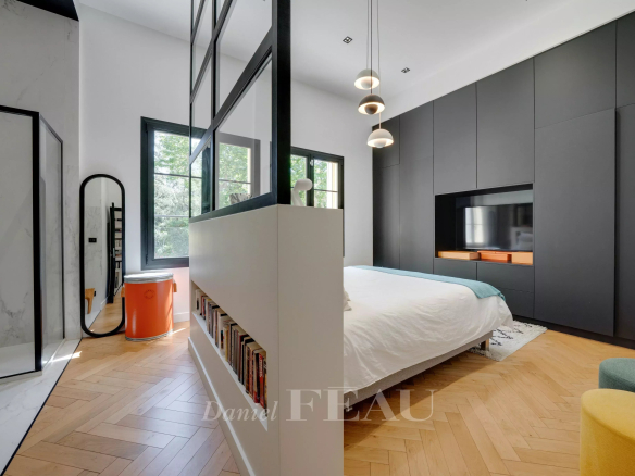 Chambre moderne avec lit, murs noirs et parquet en bois, vue sur la nature à Marseille 9ème.