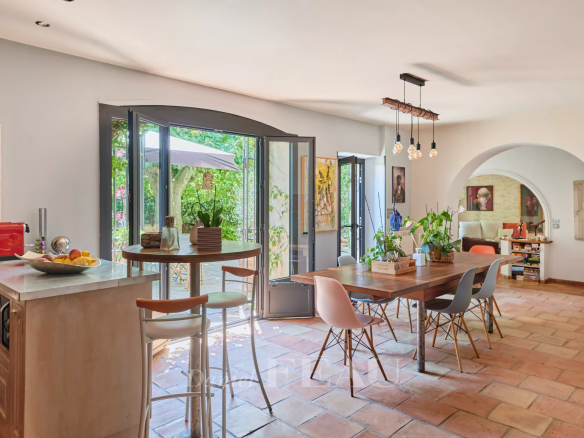 Interior of a charming house with open kitchen and dining room, natural lighting.