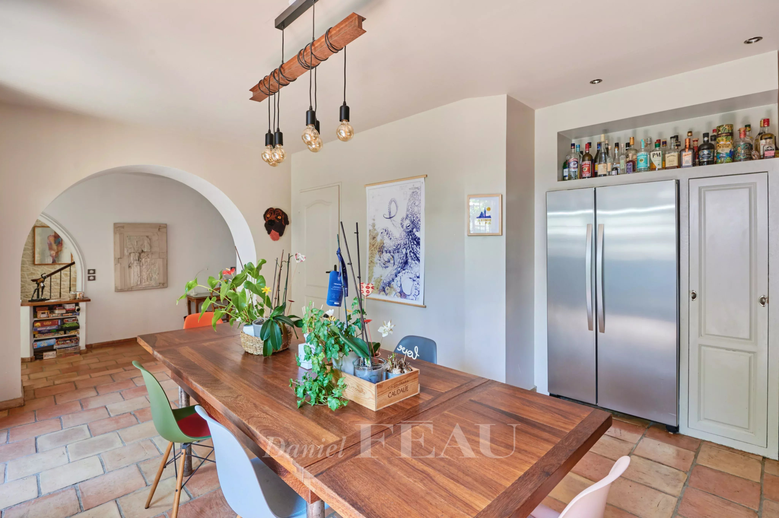 Interior of a charming house in Marseille Interior of a charming house with a large wooden table and a stainless steel refrigerator.