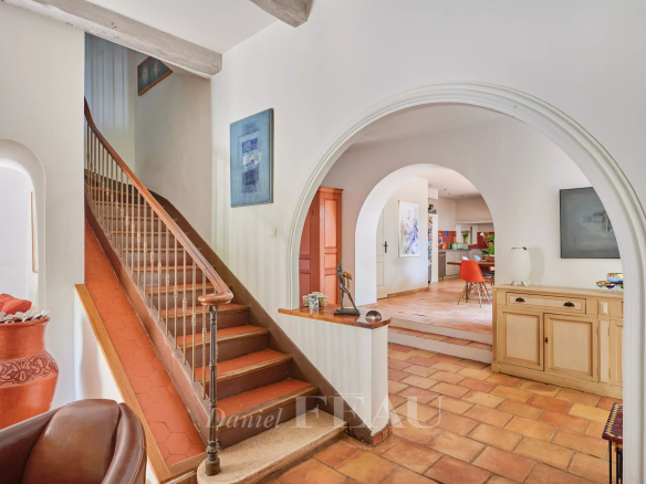 Interior of a charming house with a wooden staircase and a bright living room.