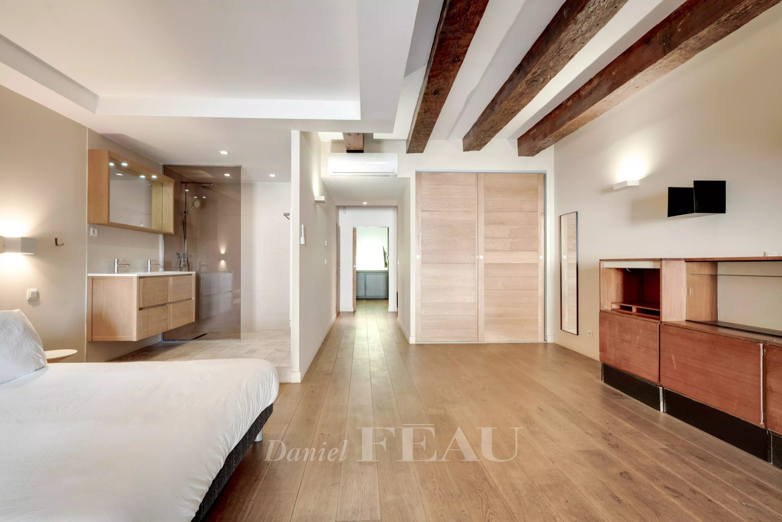 Interior of a loft with exposed beams and a modern bathroom in Marseille.