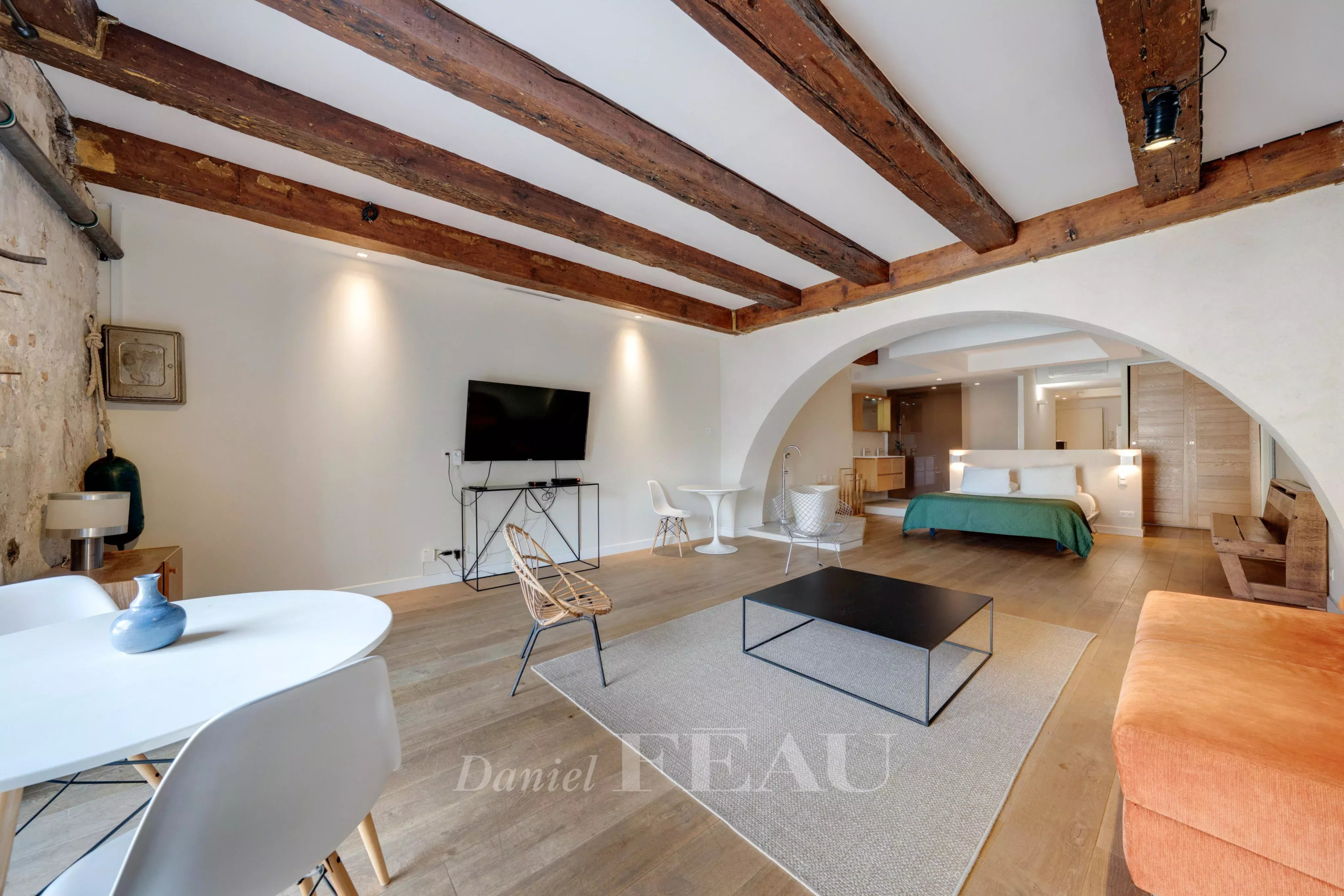 Interior of a loft in the Old Port of Marseille with exposed beams and modern furniture.