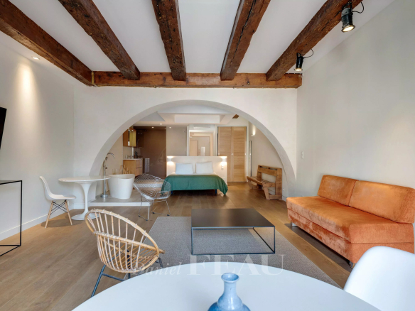 Interior of a loft in the Old Port of Marseille with exposed beams and modern furniture.