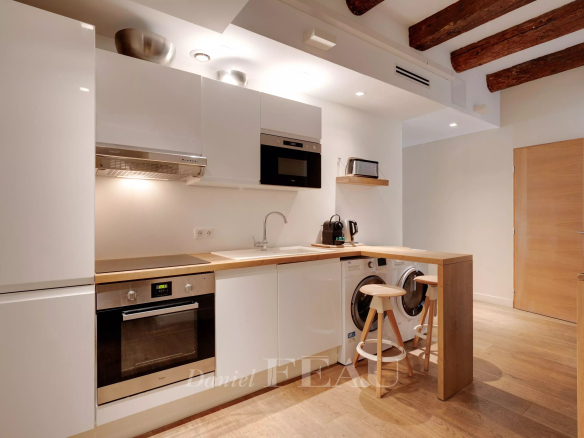 Modern loft kitchen in the Old Port of Marseille with exposed beams.