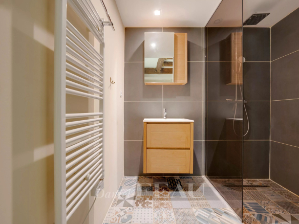 Modern bathroom with walk-in shower and wooden furniture in a loft in Marseille.