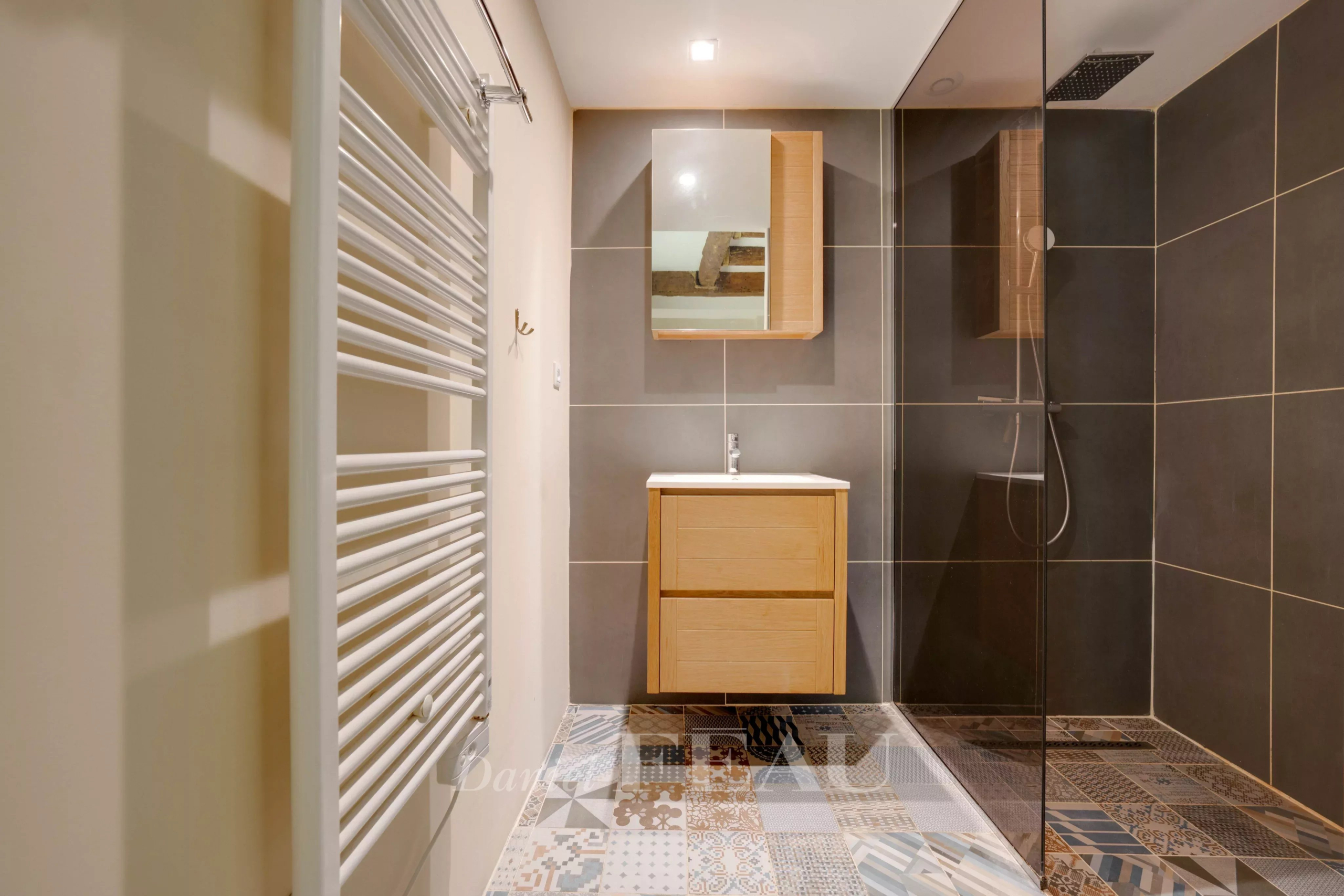 Modern bathroom with walk-in shower and wooden furniture in a loft in Marseille.