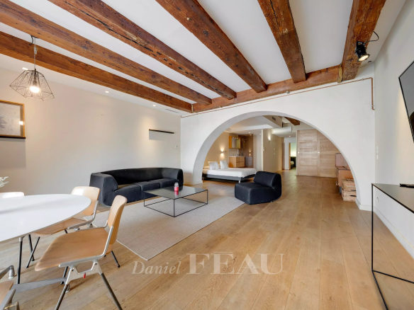 Interior of a loft in the Old Port of Marseille with exposed beams and modern furniture.