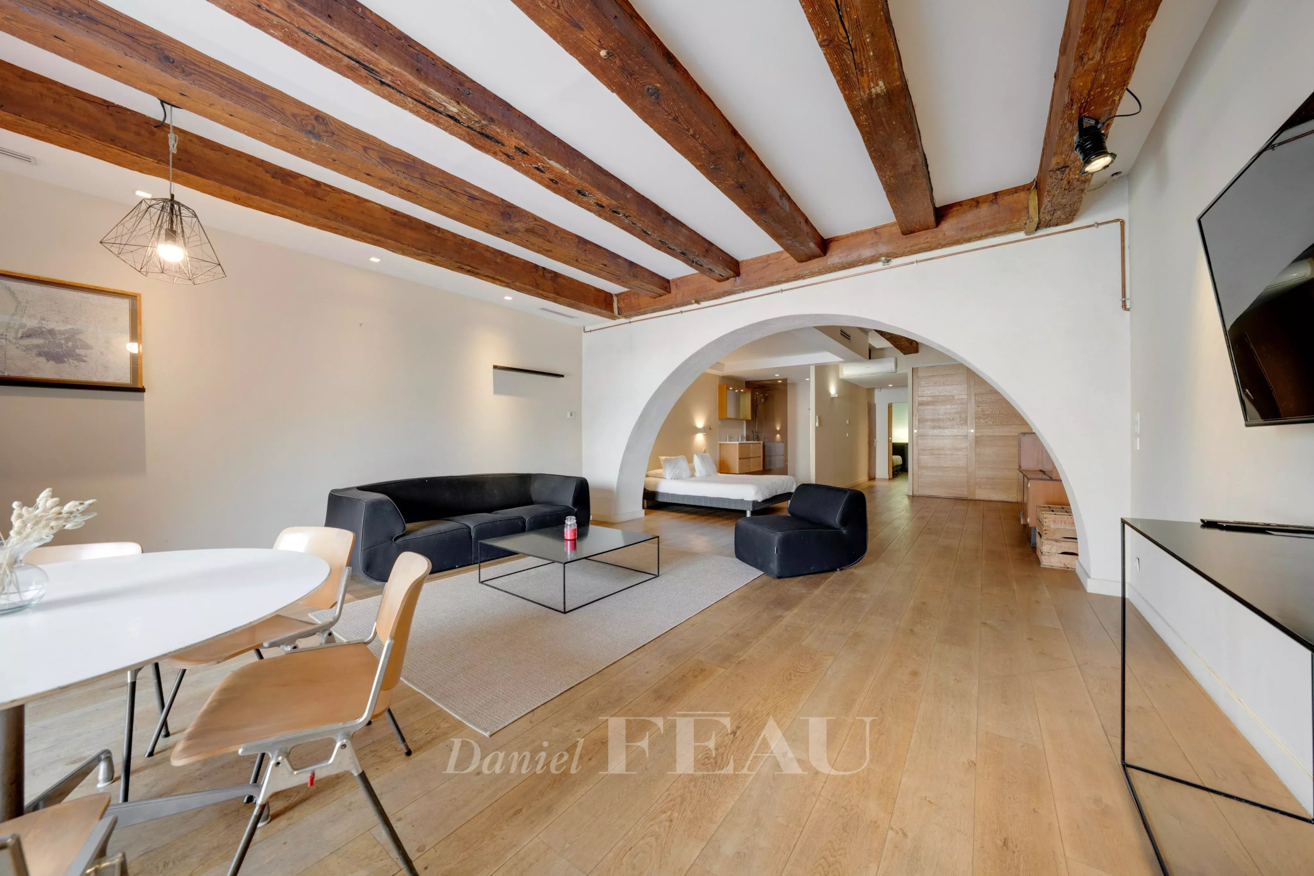 Interior of a loft in the Old Port of Marseille with exposed beams and modern furniture.