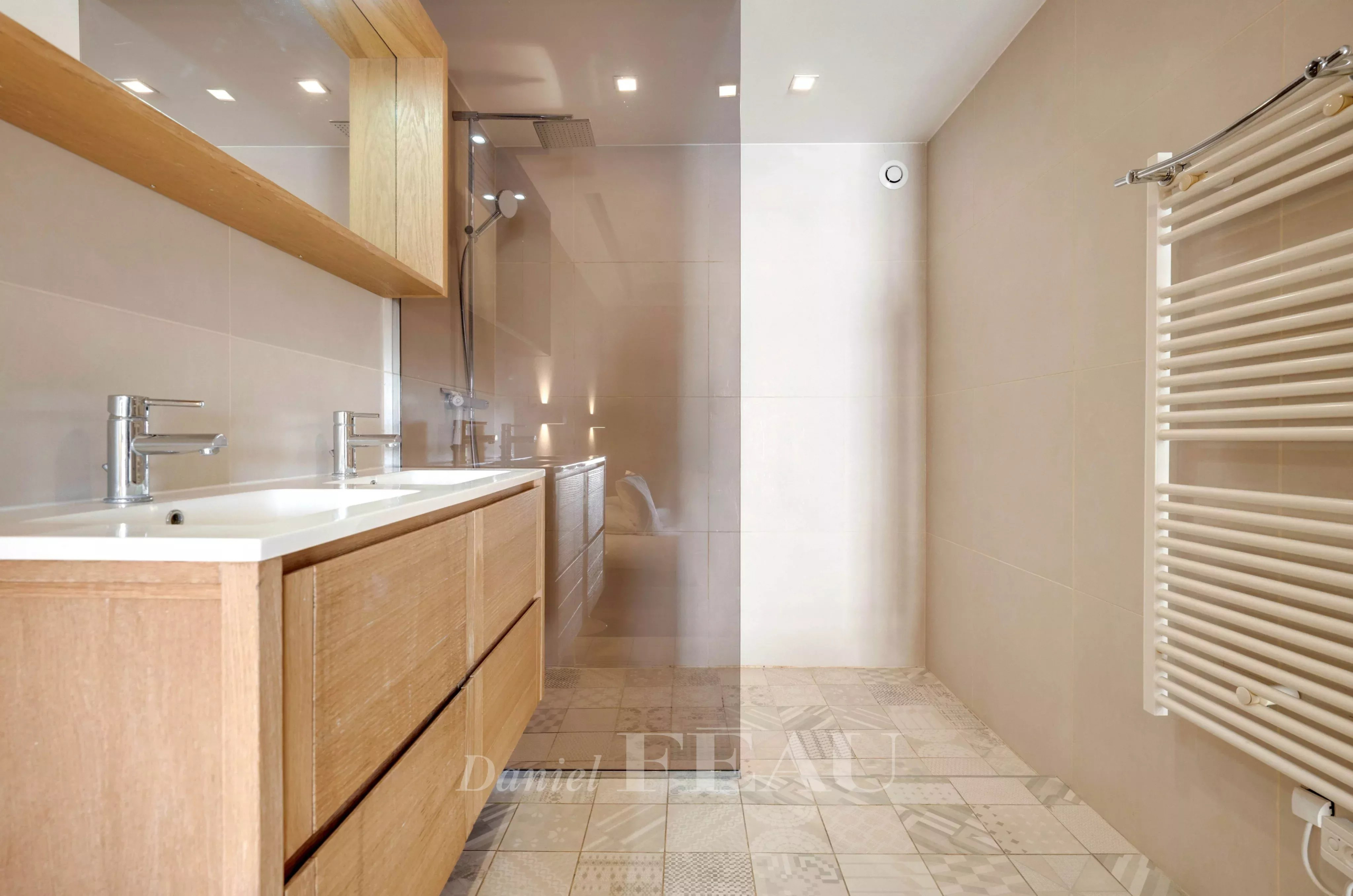 Modern bathroom with wooden furniture and glass shower.