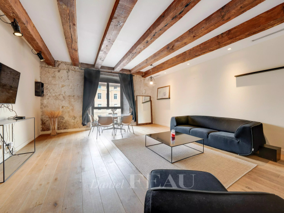 Interior of a loft in the Old Port of Marseille with exposed beams and modern furniture.