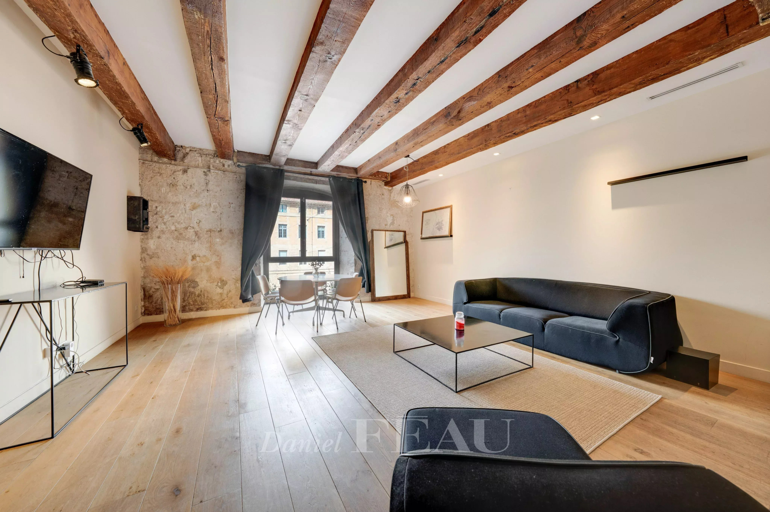 Interior of a loft in the Old Port of Marseille with exposed beams and modern furniture.