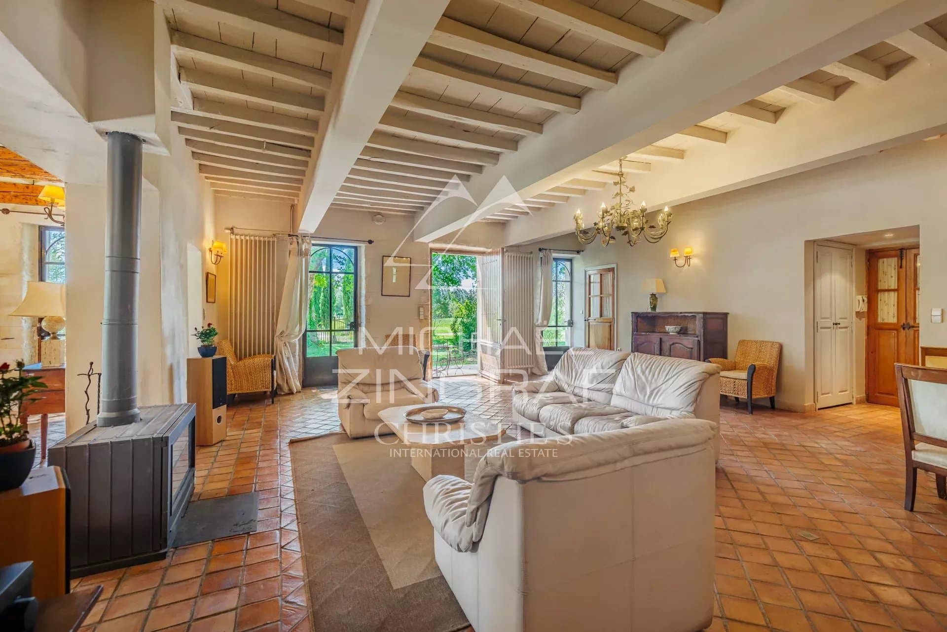 Interior of a characterful residence with a spacious living room and fireplace, elegantly decorated.