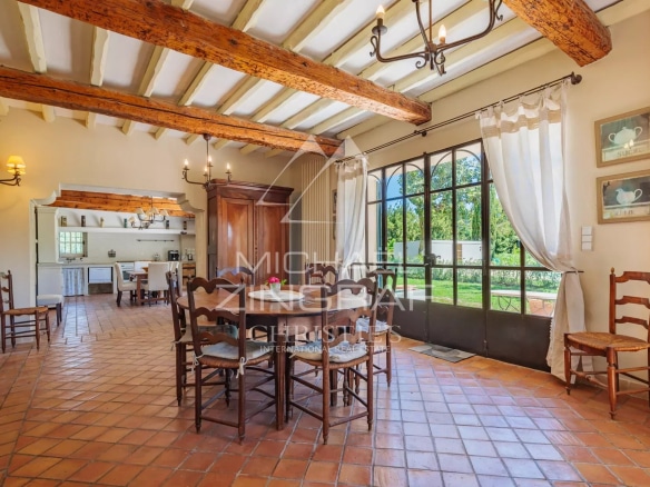 Interior of a characterful house with dining room and windows overlooking the garden.