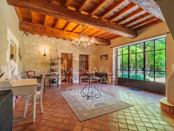 Interior of an old house with wooden beams and tiled floors, natural lighting.