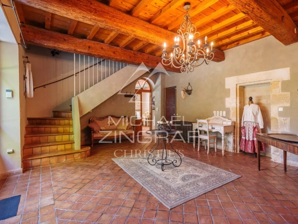 Interior of an elegant home with exposed beams and terracotta tiles.