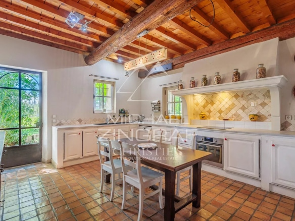Kitchen in a characterful house with exposed beams and tiled floor, located near Avignon.