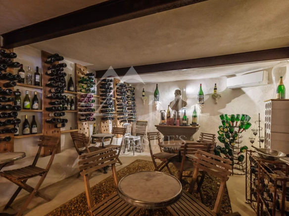 Cave à vin avec étagères et tables dans un hôtel particulier du 19ème siècle.