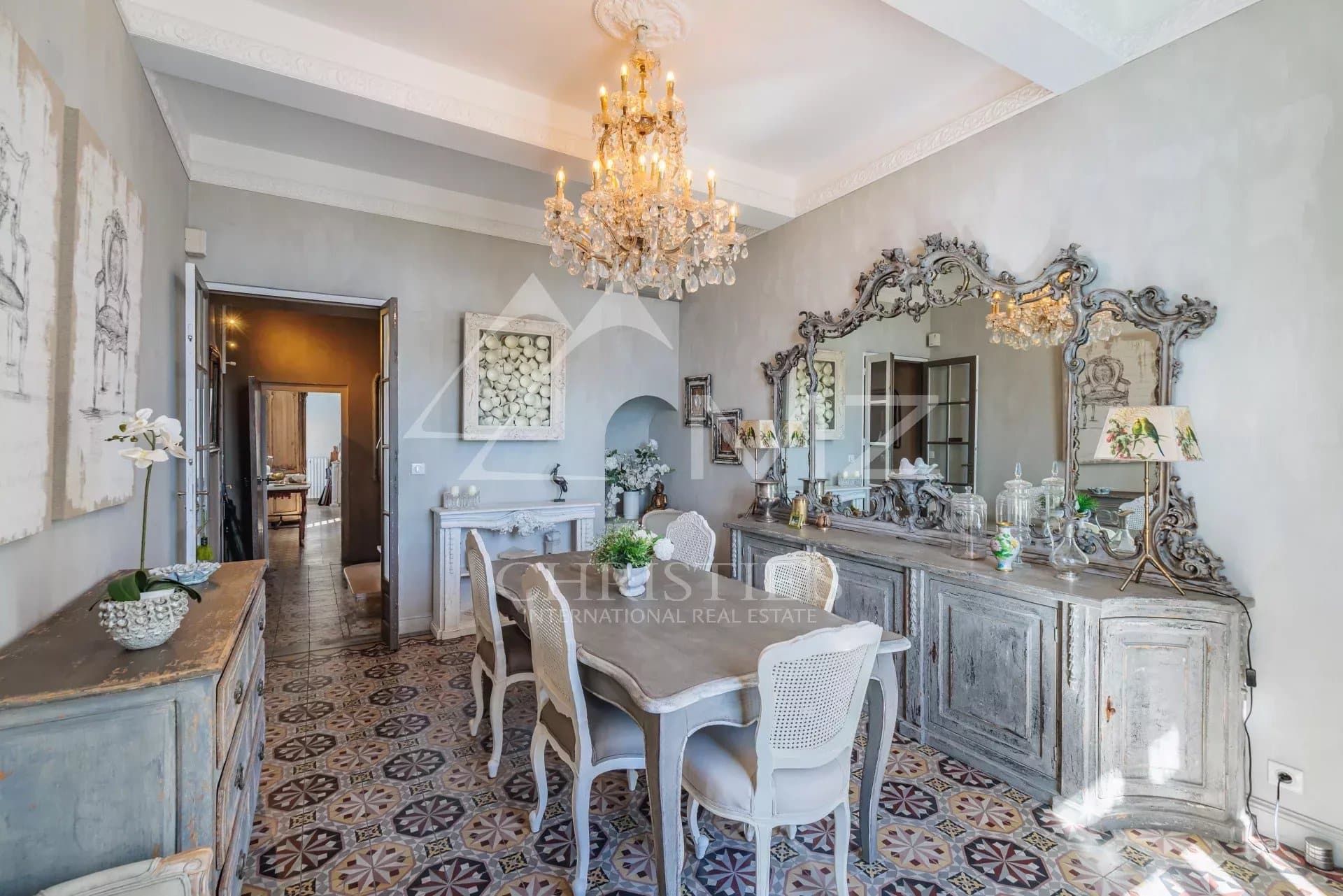 Intérieur d'une maison du 19ème siècle avec une table à manger élégante et un lustre.