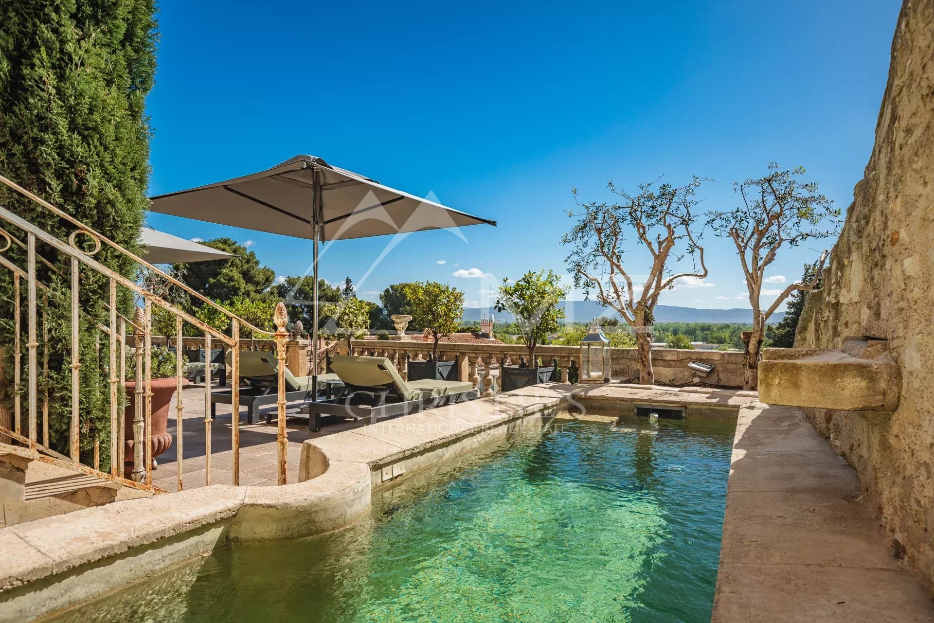 Terrasse avec piscine et vue sur les monts du Luberon dans une maison du 19ème siècle à Châteauneuf-de-Gadagne.