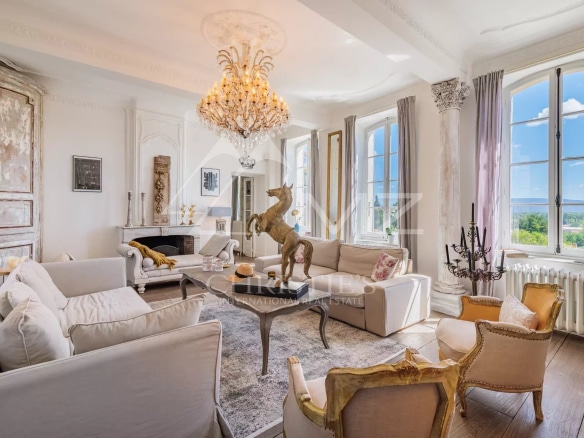 Intérieur d'un hôtel particulier du 19ème siècle avec un salon élégant et une vue sur la nature.