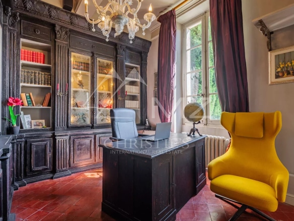 Bureau élégant avec meuble en bois noir et fauteuil jaune dans une maison du 19ème siècle.