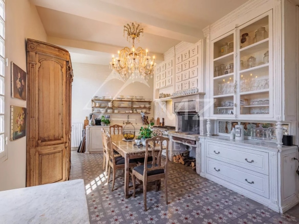 Cuisine d'une maison du 19ème siècle avec des meubles en bois et un lustre.