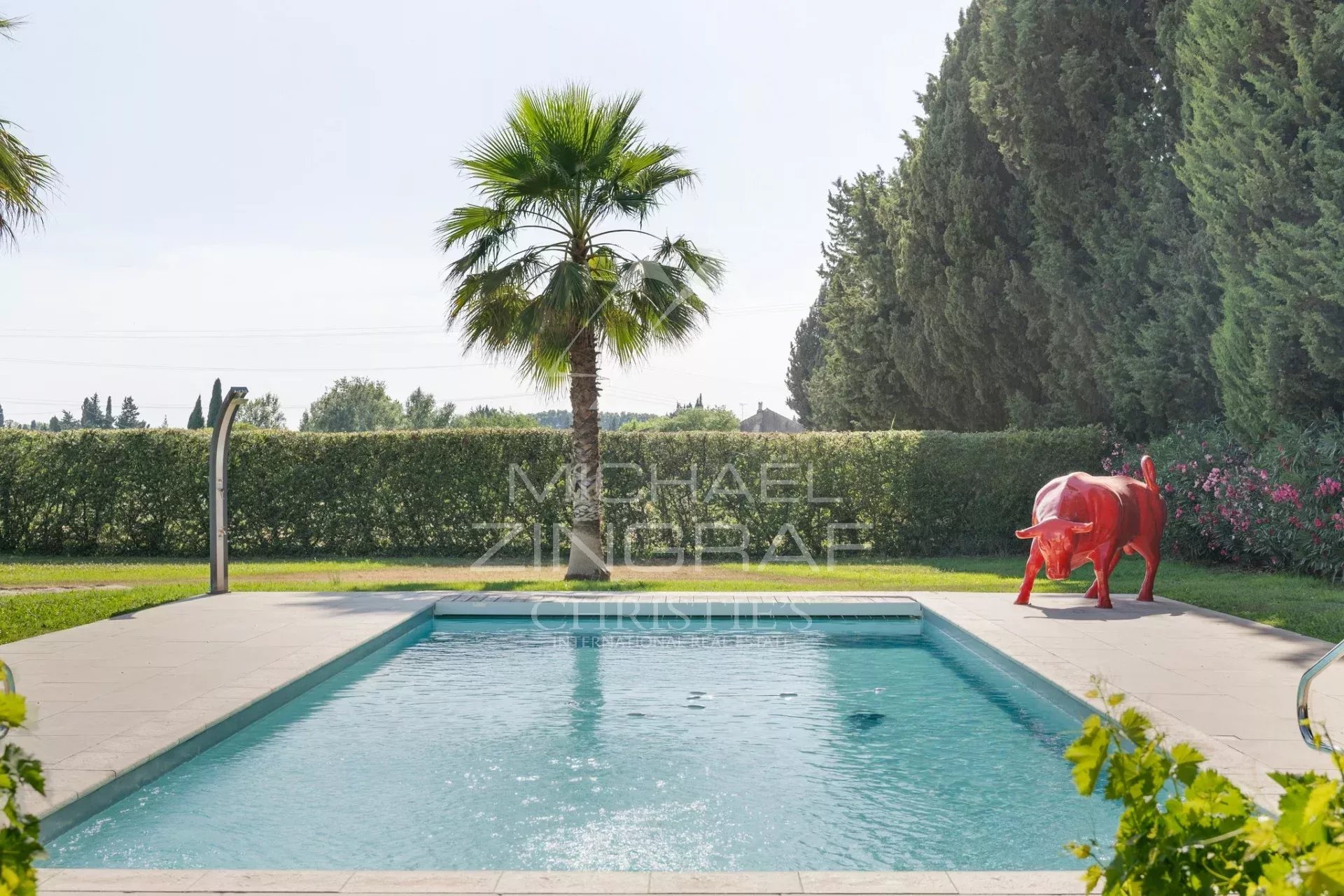 Piscine et jardin d’un mas rénové Piscine avec palmier et sculpture près d'un mas rénové à Eyragues