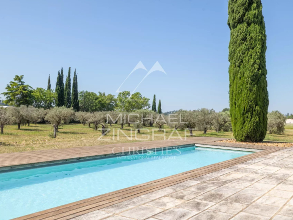 Swimming pool surrounded by olive and cypress trees on a property near Arles.