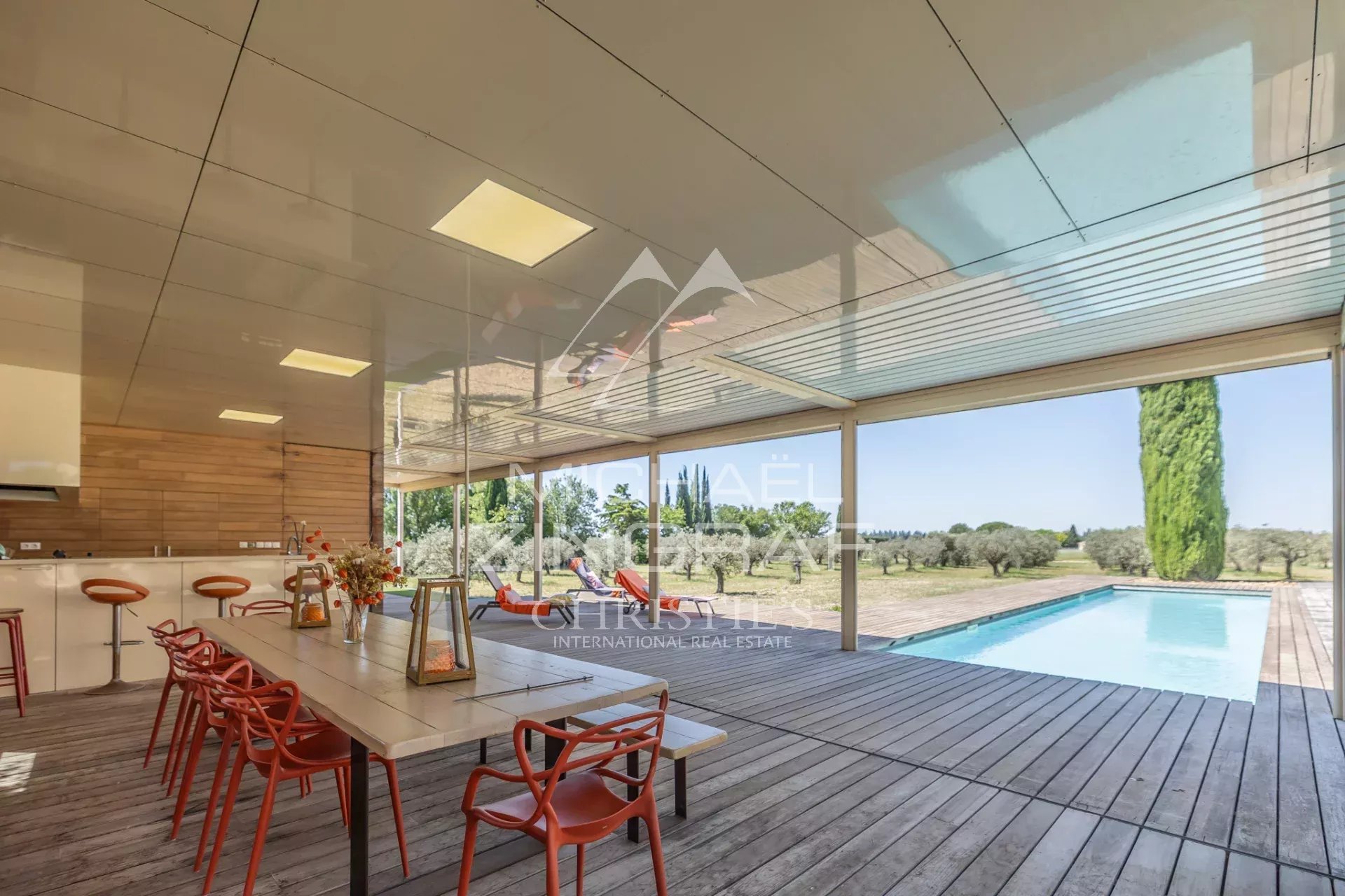 Terrace overlooking the pool Wooden terrace with table and chairs, overlooking the pool and Provençal landscape.
