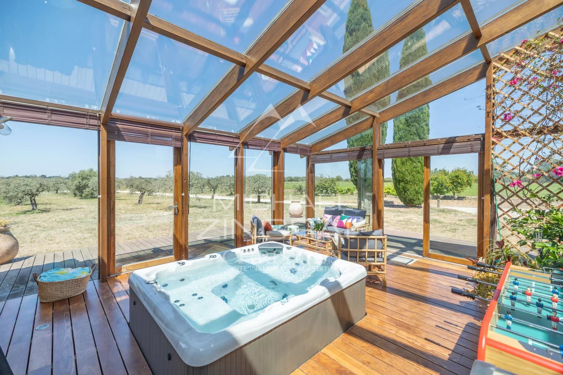 Relaxation area with jacuzzi Relaxation area with jacuzzi and wooden lounge, surrounded by greenery.