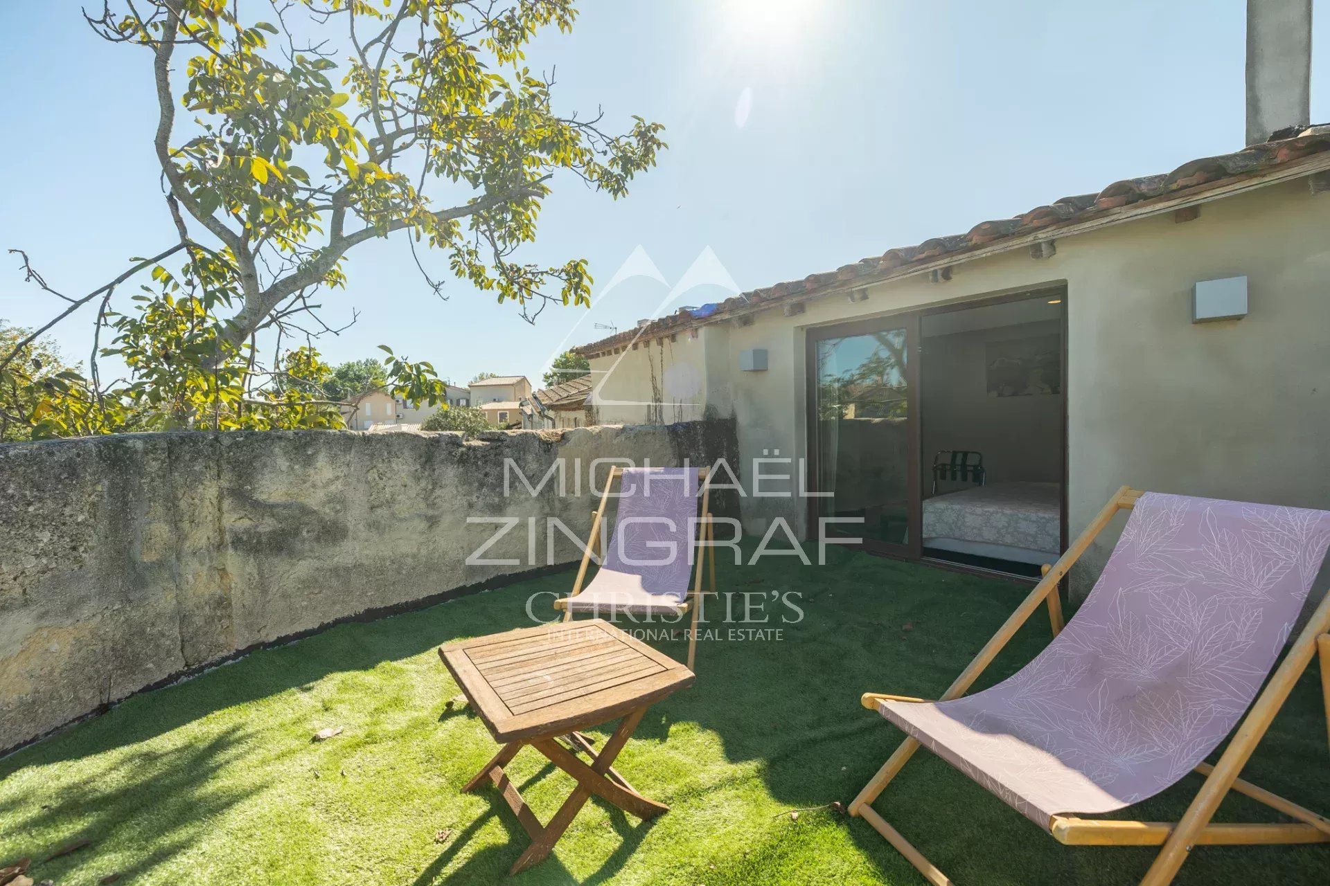 Terrasse d’une maison provençale Terrasse d'une maison provençale avec chaise longue et table, entourée de murs en pierre.