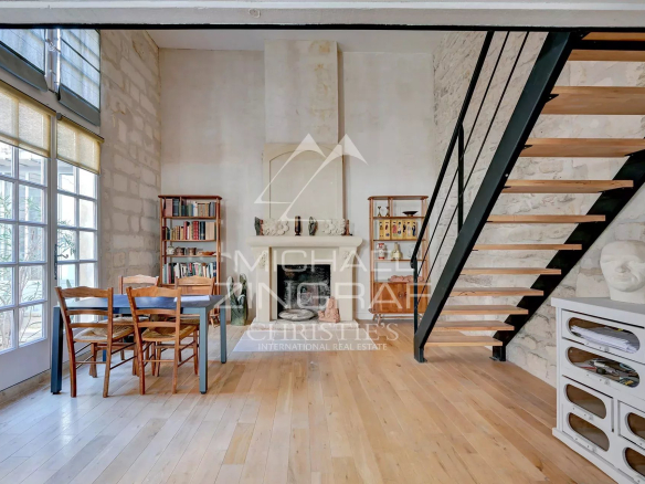 Intérieur d'un appartement rénové dans un hôtel particulier du XVIIème siècle à Avignon, avec escalier et mobilier en bois.