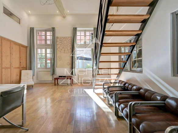 Intérieur d'un appartement dans un hôtel particulier du XVIIème siècle à Avignon, avec un escalier et des fenêtres lumineuses.