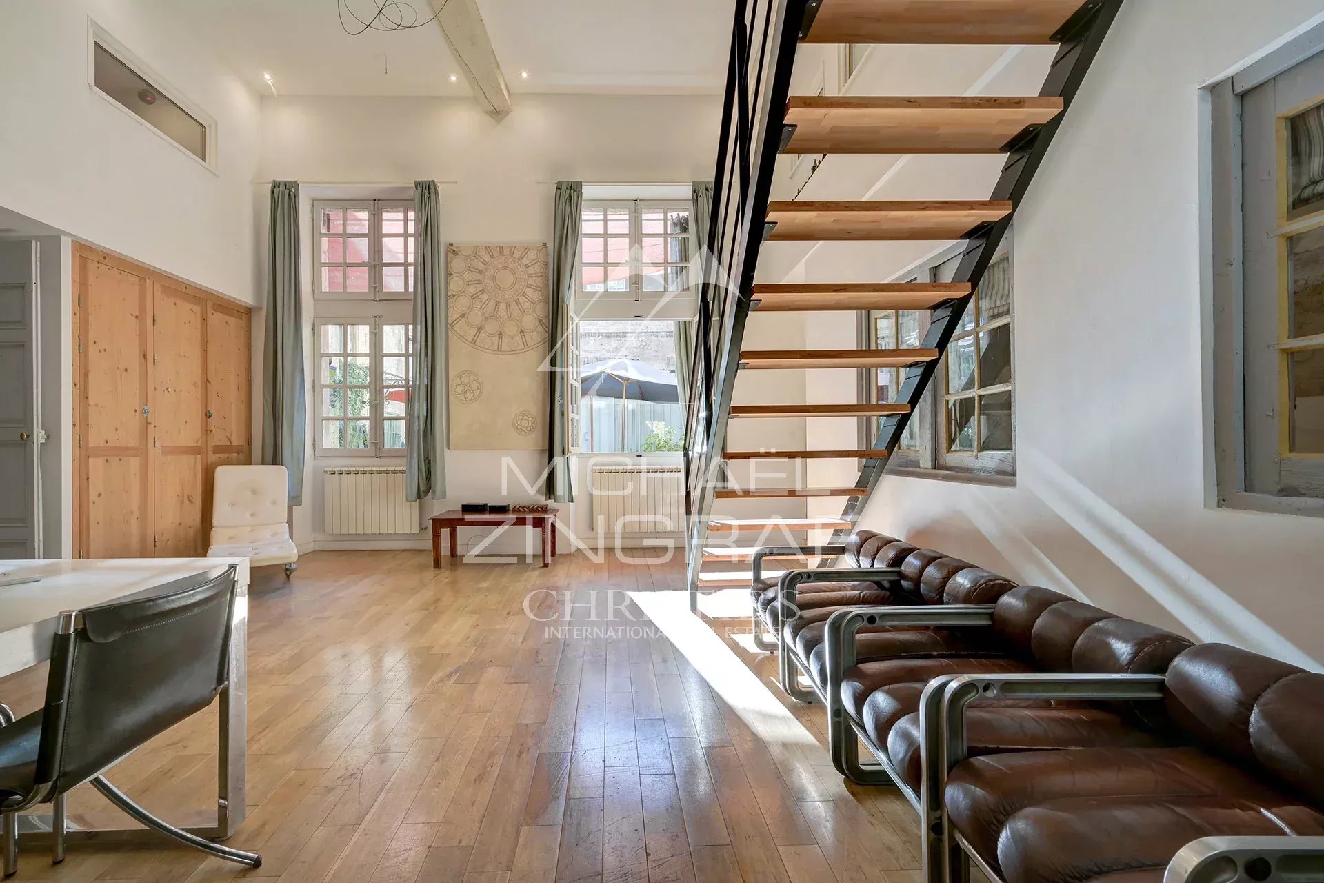Appartement dans un hôtel particulier à Avignon Intérieur d'un appartement dans un hôtel particulier du XVIIème siècle à Avignon, avec un escalier et des fenêtres lumineuses.