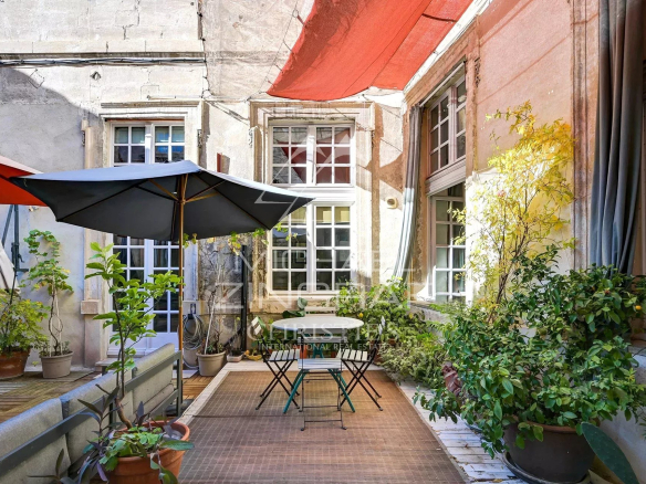 Terrasse ensoleillée d'un appartement dans un hôtel particulier du XVIIème siècle à Avignon.