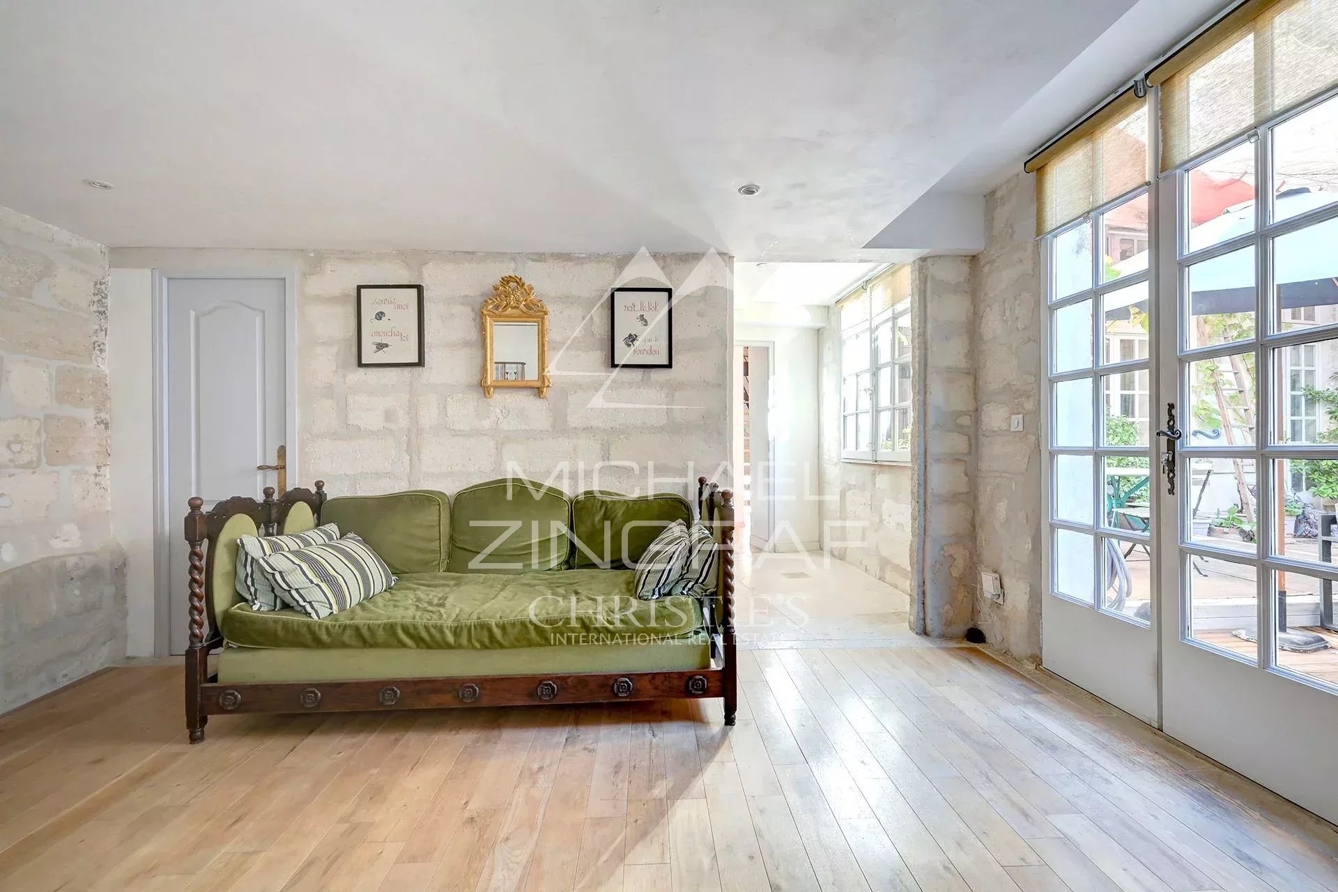 Appartement rénové à Avignon Intérieur d'un appartement rénové avec un canapé et des murs en pierre, lumière naturelle