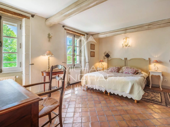 Chambre d'une demeure de caractère à Avignon, avec lit, bureau et fenêtres donnant sur la nature.